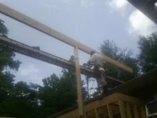 Carpenter setting a ridge beam over a new addition frame — Ice Dam Removal by Roofing Brothers in Red Cliff
