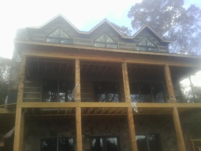 Dormers and porch framing on a large log home under construction — Roof Coating work by our crew in Red Cliff