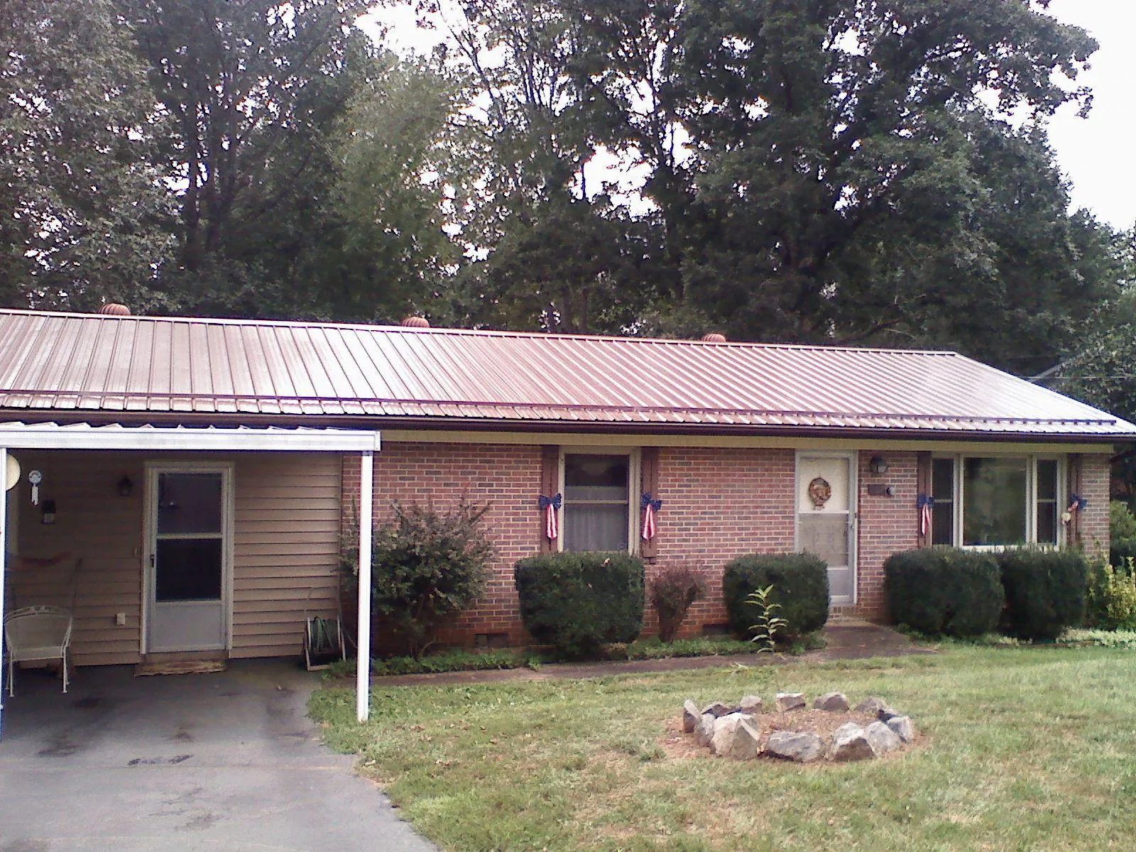 Bronze metal roof and carport on a brick ranch home — Roof Repair work by our crew in Red Cliff